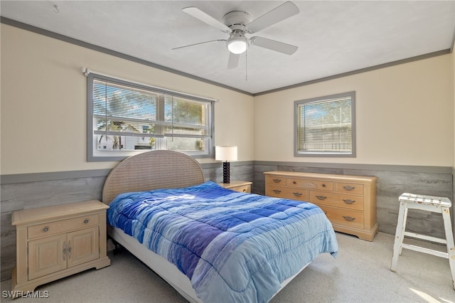 bedroom featuring crown molding, light colored carpet, and ceiling fan