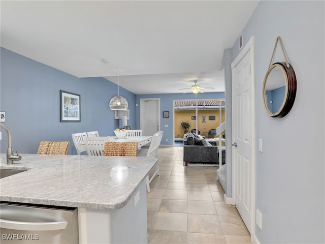 kitchen featuring decorative light fixtures, sink, stainless steel dishwasher, light tile patterned floors, and ceiling fan