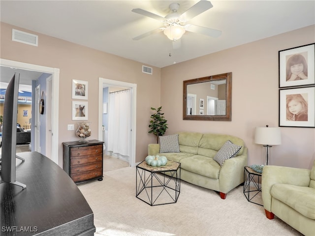 carpeted living room with ceiling fan