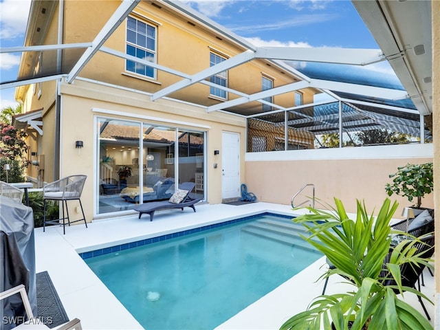 view of swimming pool featuring glass enclosure