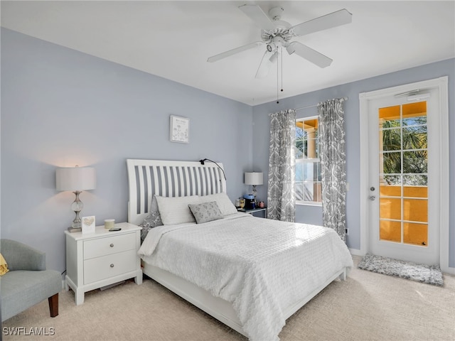 bedroom featuring access to outside, light colored carpet, and ceiling fan