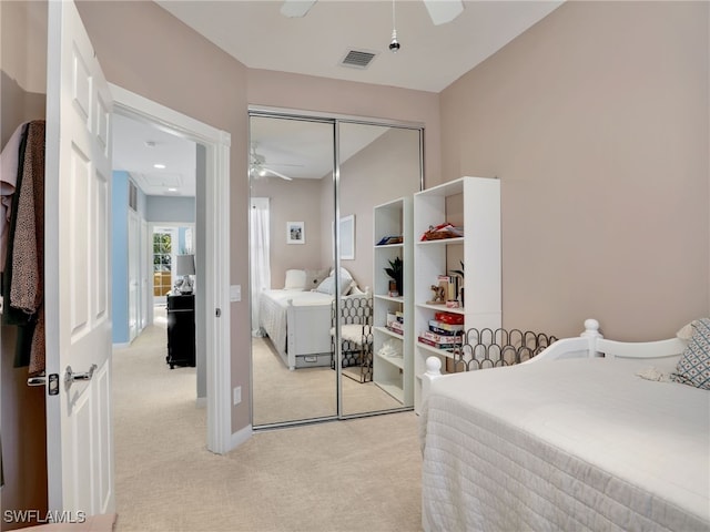 carpeted bedroom with ceiling fan and a closet