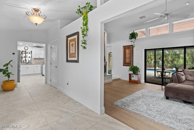 hallway featuring light hardwood / wood-style flooring and a high ceiling