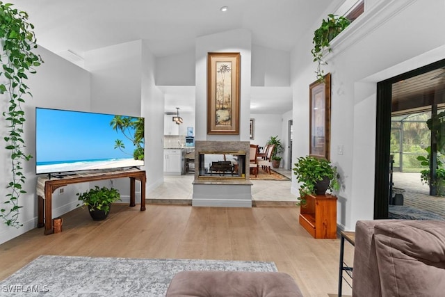 living room with high vaulted ceiling and light wood-type flooring