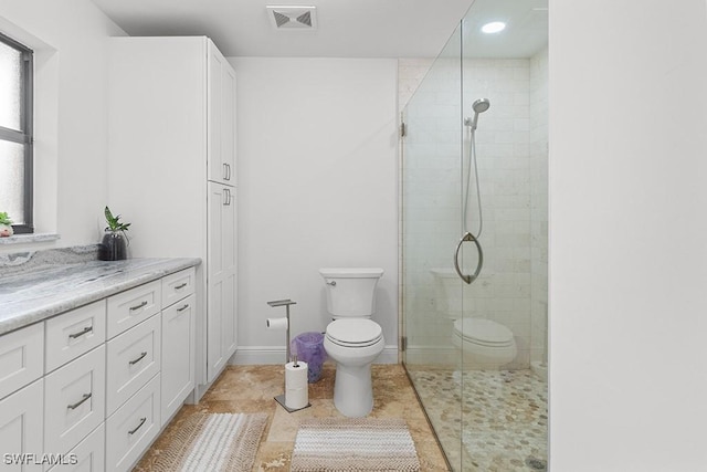 bathroom featuring tile patterned floors, toilet, a shower with shower door, and vanity