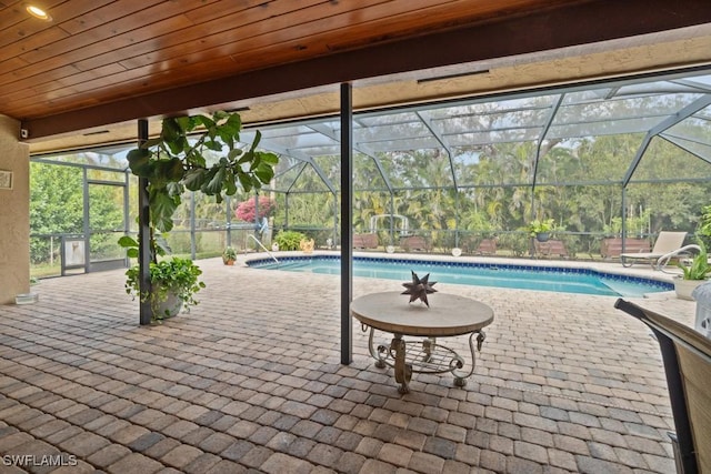 view of swimming pool featuring a patio and glass enclosure