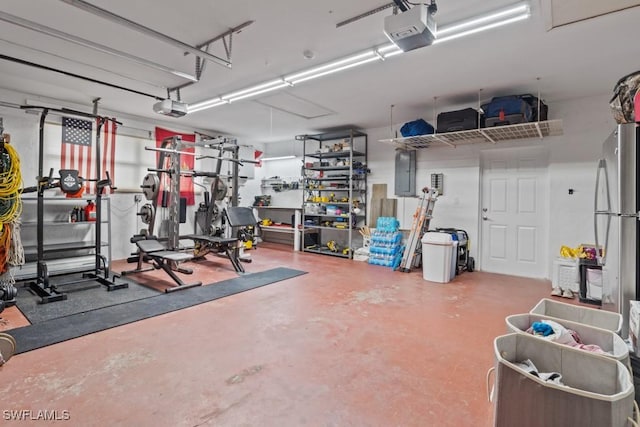 garage featuring a garage door opener, stainless steel fridge, and electric panel