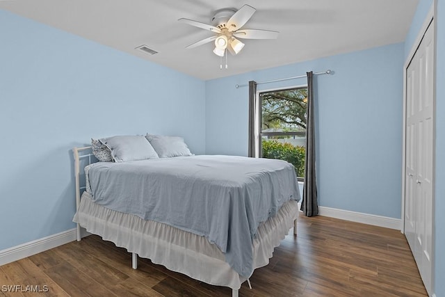 bedroom with a closet, dark hardwood / wood-style floors, and ceiling fan