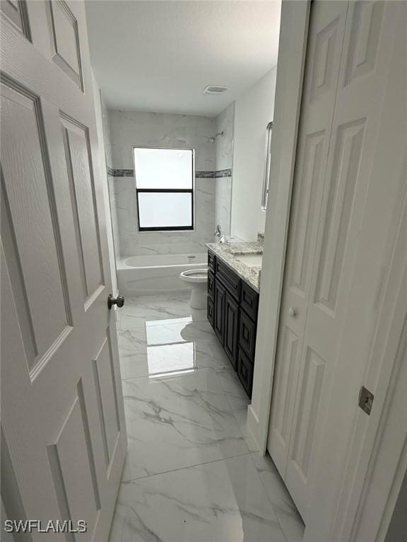 full bathroom with vanity, tiled shower / bath, and toilet