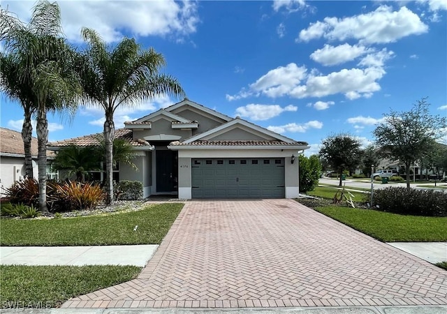 4176 Madison St, Ave Maria, FL 34142 - view of front facade featuring stucco siding, an attached garage, decorative driveway, and a front lawn