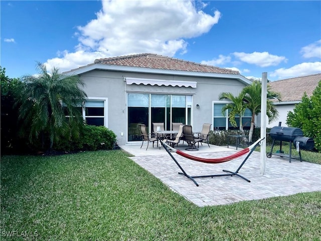 4176 Madison St, Ave Maria, FL 34142 - rear view of property featuring stucco siding, a yard, and a patio area