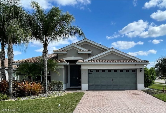 4176 Madison St, Ave Maria, FL 34142 - ranch-style home featuring stucco siding, a garage, decorative driveway, and a front yard