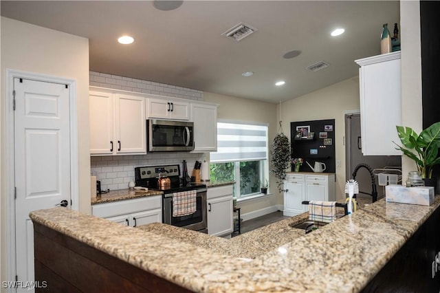 4176 Madison St, Ave Maria, FL 34142 - kitchen featuring appliances with stainless steel finishes, white cabinets, light stone counters, backsplash, and lofted ceiling
