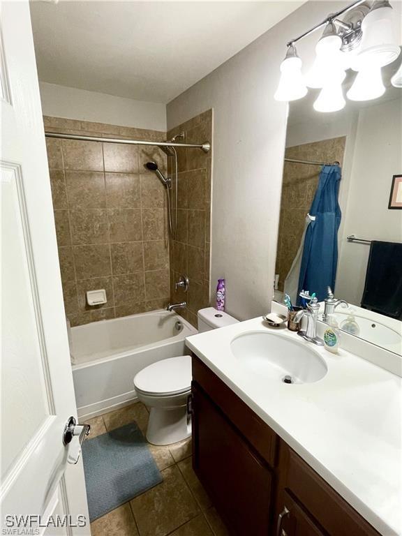 4176 Madison St, Ave Maria, FL 34142 - bathroom featuring tile patterned flooring, shower / tub combo, vanity, and toilet
