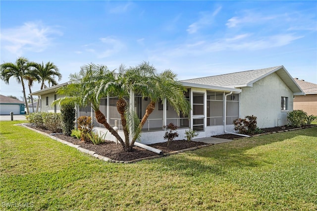 view of front of house featuring a sunroom and a front lawn