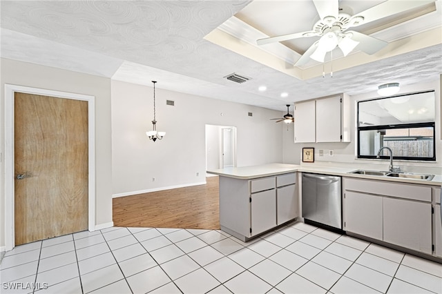 kitchen with pendant lighting, sink, ceiling fan with notable chandelier, stainless steel dishwasher, and kitchen peninsula