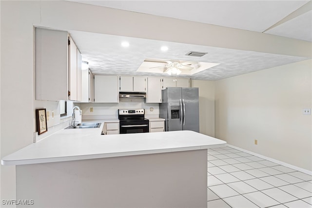 kitchen featuring sink, ceiling fan, stainless steel appliances, a tray ceiling, and kitchen peninsula