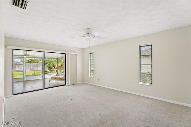 carpeted spare room with a textured ceiling and ceiling fan