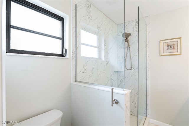 bathroom featuring toilet and a tile shower