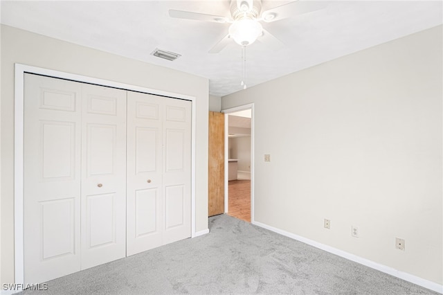 unfurnished bedroom with light carpet, ceiling fan, and a closet