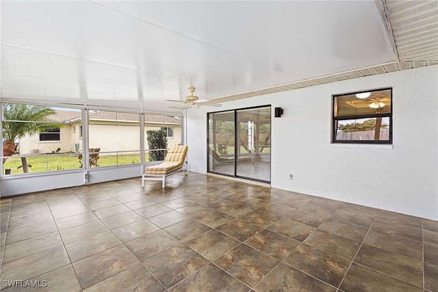 unfurnished sunroom with ceiling fan