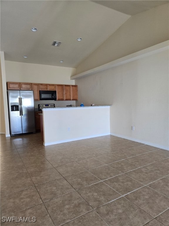 kitchen featuring stainless steel fridge with ice dispenser, tile patterned floors, and lofted ceiling