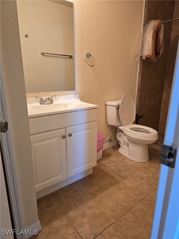 bathroom featuring a shower, toilet, tile patterned flooring, and vanity