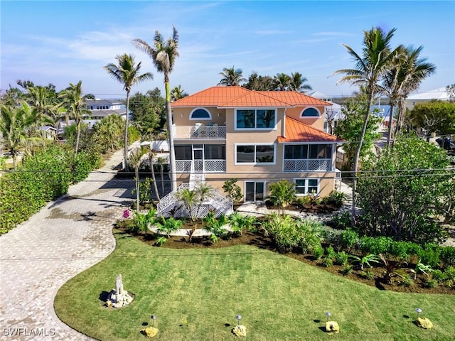 mediterranean / spanish house with a sunroom and a front lawn