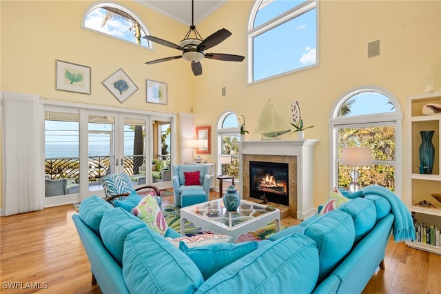 living room featuring crown molding, a healthy amount of sunlight, ceiling fan, and light hardwood / wood-style flooring