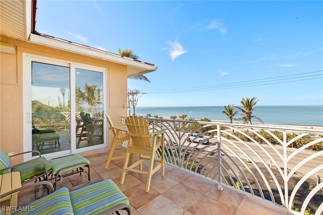 balcony with a water view and a view of the beach