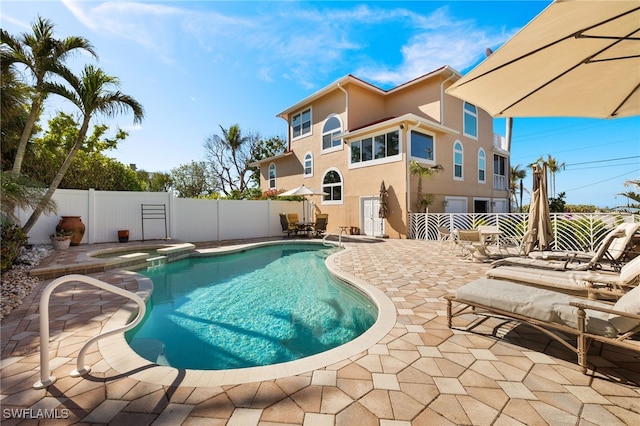 view of pool featuring a patio area and an in ground hot tub