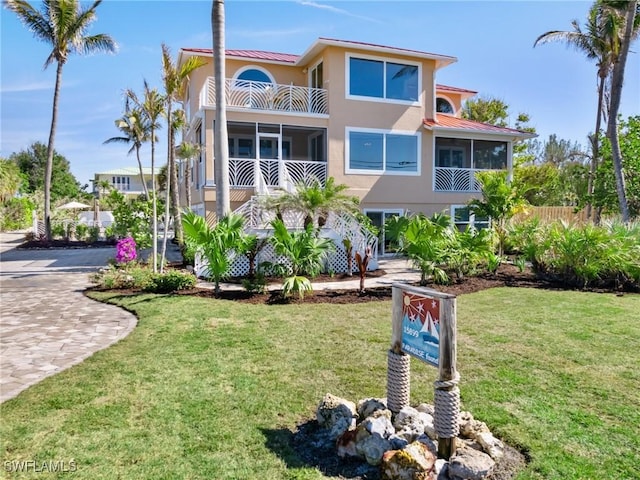 view of front of house featuring a balcony and a front yard