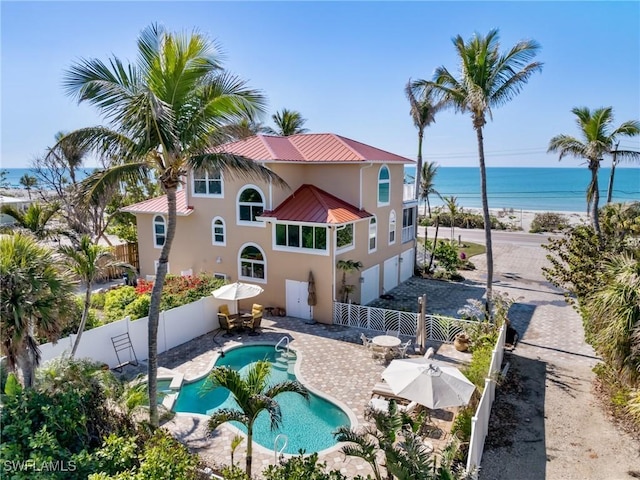 back of property featuring a fenced in pool, a water view, and a patio area