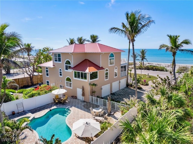 back of property featuring a fenced in pool, a water view, and a patio area