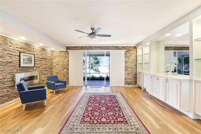 living area featuring light wood-type flooring and a ceiling fan