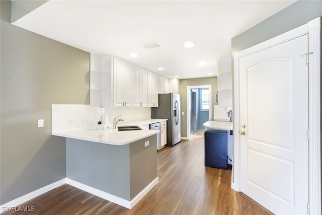 kitchen featuring dark wood-style floors, open shelves, a sink, and light countertops