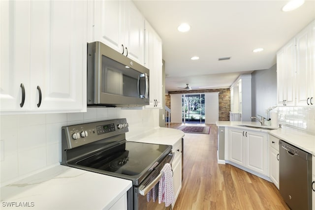 kitchen with light wood-style floors, white cabinetry, appliances with stainless steel finishes, and a sink