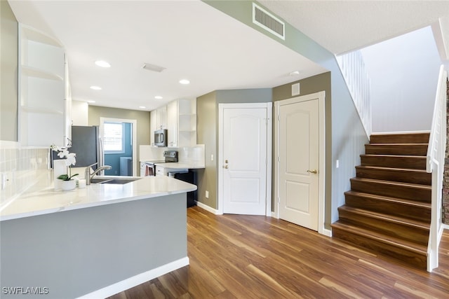 kitchen with white cabinetry, stainless steel appliances, visible vents, and open shelves