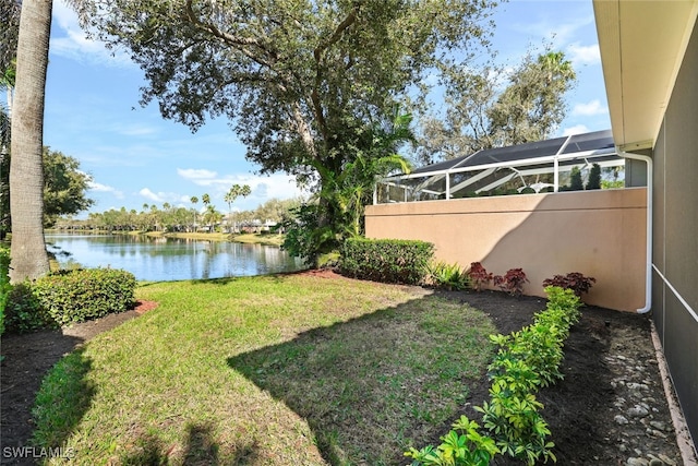 view of yard with glass enclosure and a water view