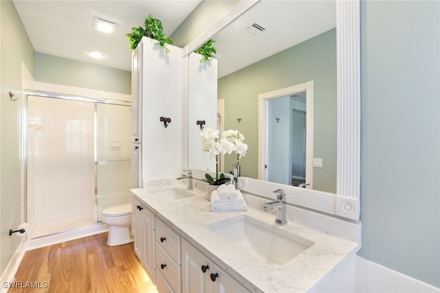 full bathroom with visible vents, a sink, toilet, and wood finished floors