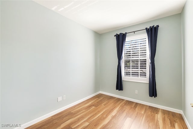 unfurnished room featuring baseboards and wood finished floors