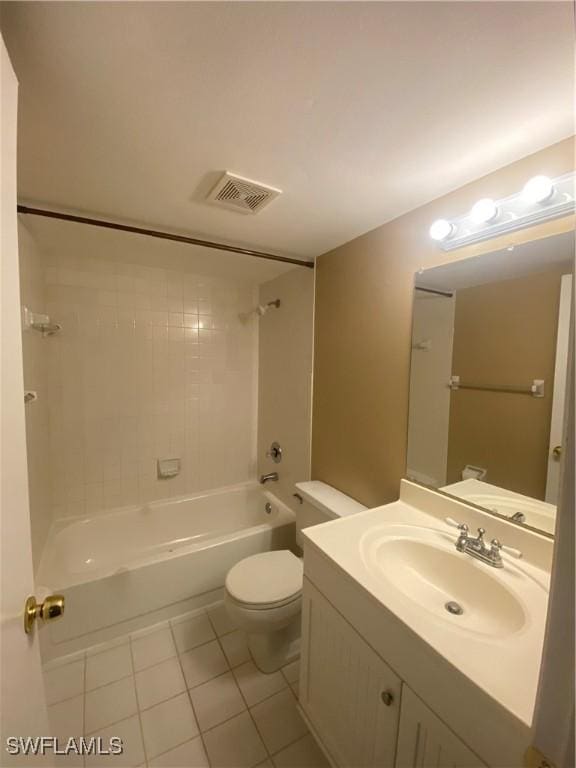 full bathroom featuring tile patterned flooring, vanity, tiled shower / bath combo, and toilet