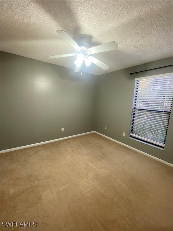 unfurnished room featuring a textured ceiling, ceiling fan, and carpet