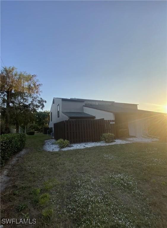 property exterior at dusk with a yard