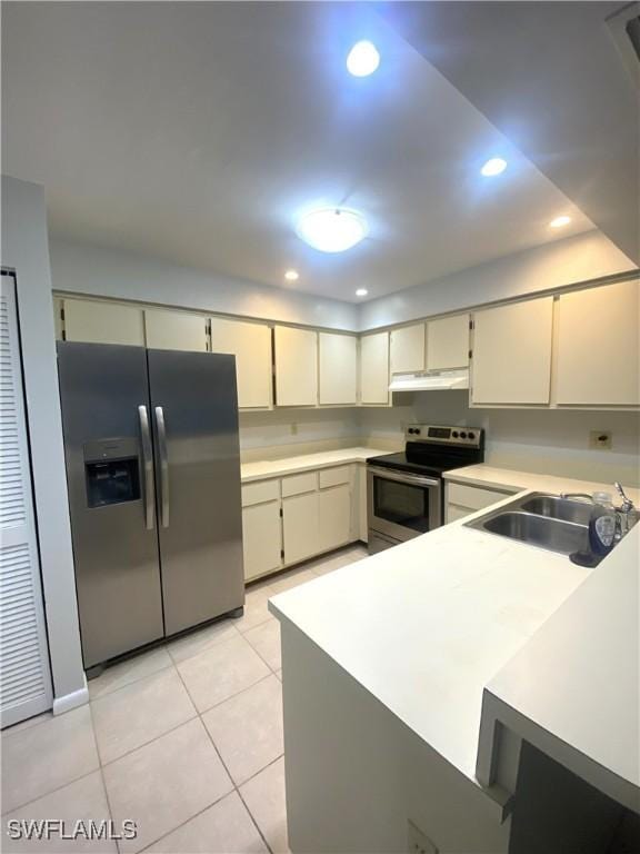 kitchen with sink, light tile patterned floors, appliances with stainless steel finishes, kitchen peninsula, and cream cabinets