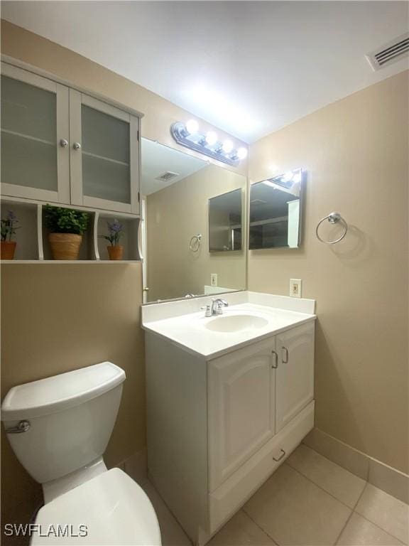 bathroom featuring vanity, tile patterned floors, and toilet