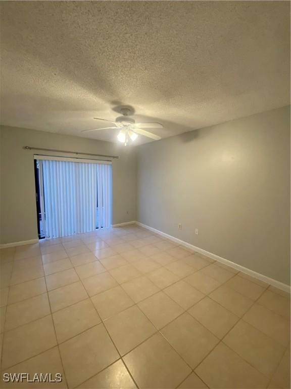 spare room with light tile patterned flooring, a textured ceiling, and ceiling fan