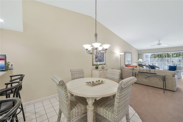 dining space with ceiling fan with notable chandelier, vaulted ceiling, and light tile patterned flooring