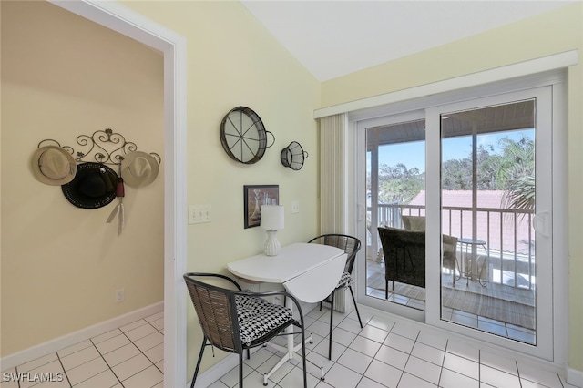 tiled dining room with lofted ceiling