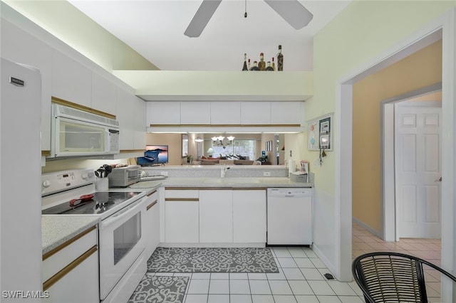 kitchen with white cabinetry, light tile patterned floors, kitchen peninsula, white appliances, and ceiling fan with notable chandelier